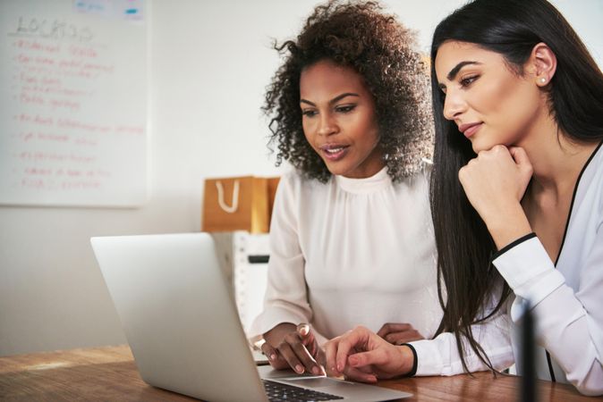 Two female colleagues working together on a laptop