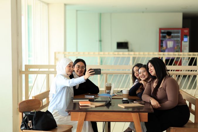 A Group of Asian  College Student Take Selfie Photo While Stduying Together using Mobile Phone