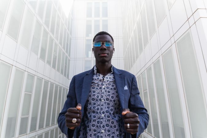 Content Black businessman listening to music in earbuds in city