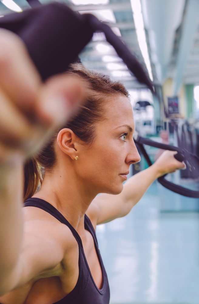 Side view of woman doing rope exercise in gym