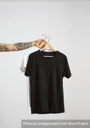 Arm holding two t-shirts on hanger 0LVOe4
