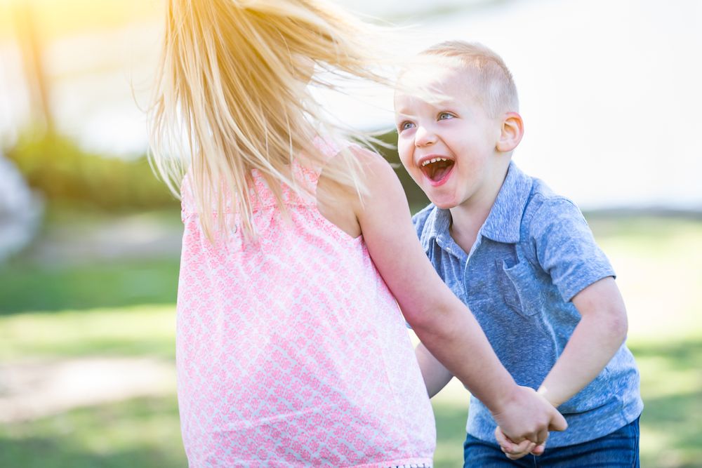 Young Brother and Sister Playing At The Park Togther