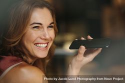 Portrait of a smiling woman holding a phone in her hand 4m21Bb