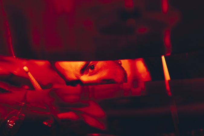 Man with drumsticks in redness