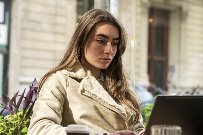 Young brunette female using laptop in a cafe