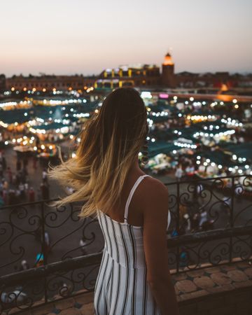 Stylish woman against oriental glowing city in night