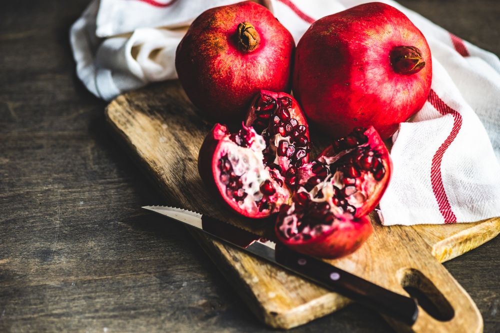Fresh cut pomegranate on board with kitchen towel
