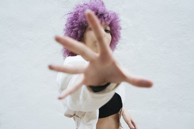 Stylish woman with pink hair trying to catch camera