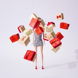 Doll in silver glittering dress with Christmas gifts or presents boxes
