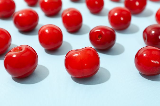 Flat lay with red cherry on blue background, close up