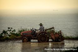 Side view of farmer riding a tractor on water 42Egg5