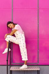 Chinese woman standing on stairs in front of pink trailer with leg over railings