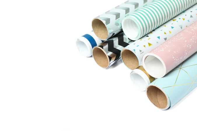 Rolls of festive wrapping paper on plain background. Space for text