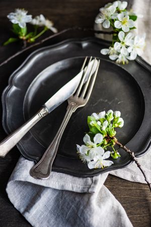 Spring table setting with blossoms on a dark plate