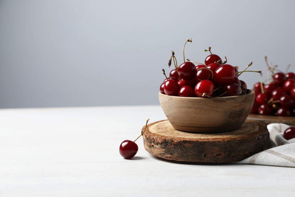 Ripe juicy fruits in a bowl on a wooden stand