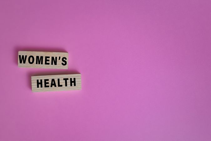 women health words text on wooden blocks isolated on pink background