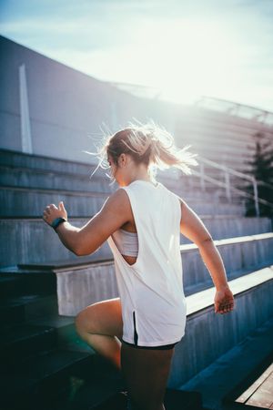 Young woman exercising on stadium stairs