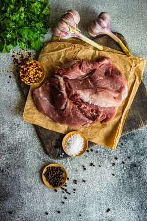 Top view of meat, spices and herbs on cutting board