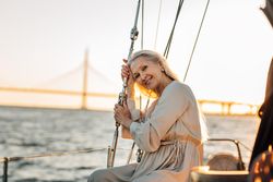 Woman relaxing on a sailboat at dusk smiling