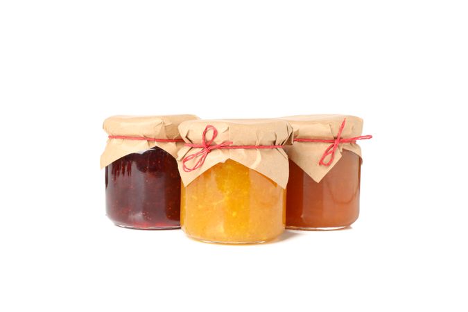 Glass jars with jam isolated on blank background