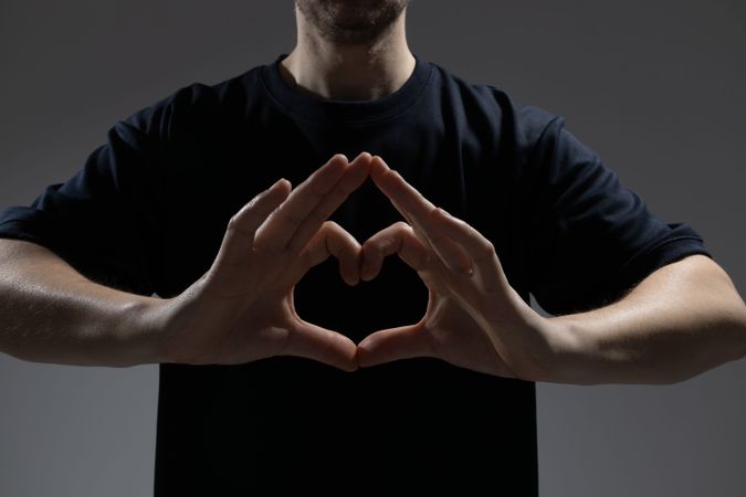 Male hands forming heart