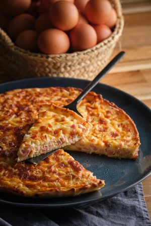 Plate with quiche near basket of eggs