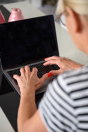 Crop woman typing on laptop