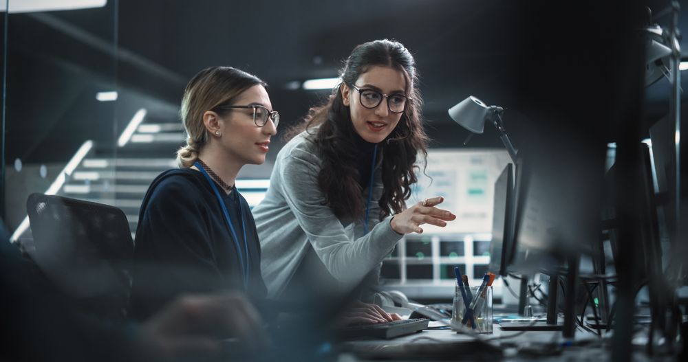 Two Diverse Colleagues Having a Conversation While Busy Working on a Team Project.