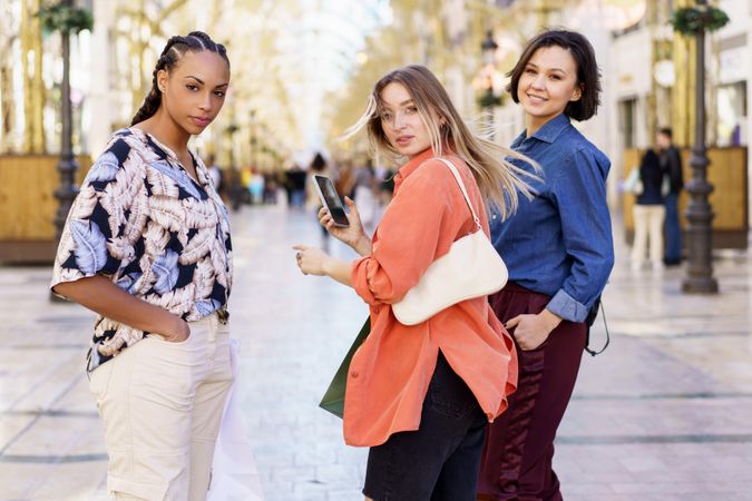 Three women looking back in shopping area