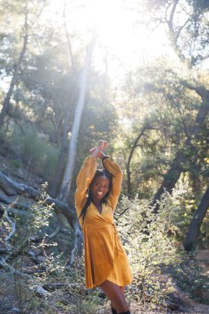Smiling woman in fashionable velvet dress in the woods