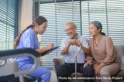 Asian nurse doing a check up for smiling older Asian couple at home 49mmoa
