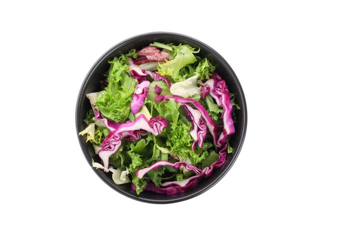 Black bowl with fresh salad isolated on plain background