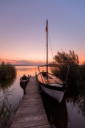 Moored boat by wooden pier