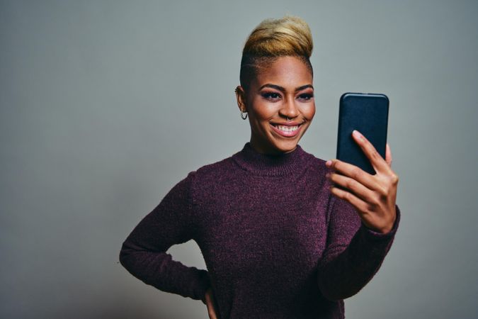 Black woman smiling while video calling on a cell phone