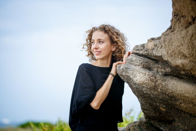 Young woman posing near stone