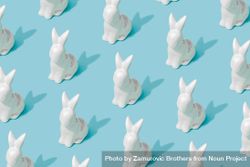 Pattern composition of Easter bunnies on pastel blue background bYeAYb