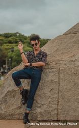 Young man with sunglasses leaning on rock 4mBqQb