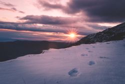 Sun setting over snowy mountains