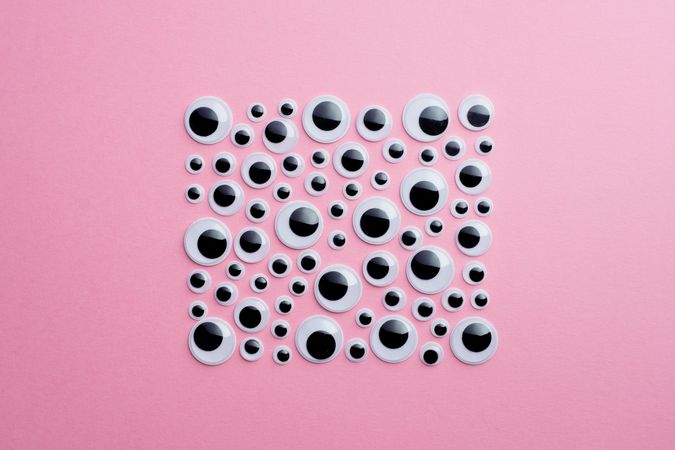 Googly eyes on pink background