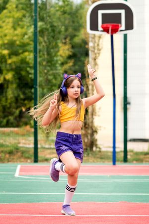 Schoolgirl dancing on sports ground