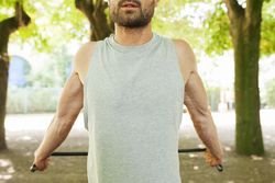 Sportsman stretching and resting with rubber in park