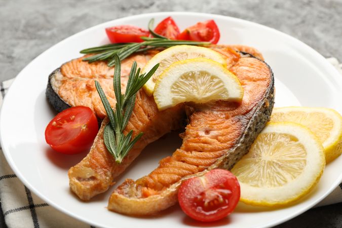 Composition with tasty grilled salmon on gray background, close up