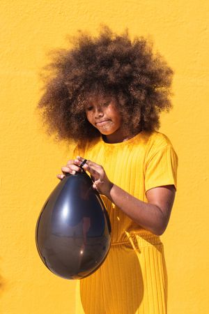 Black girl blowing party balloon