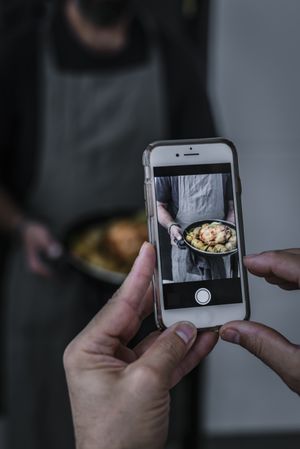 Person photographing cook and dish