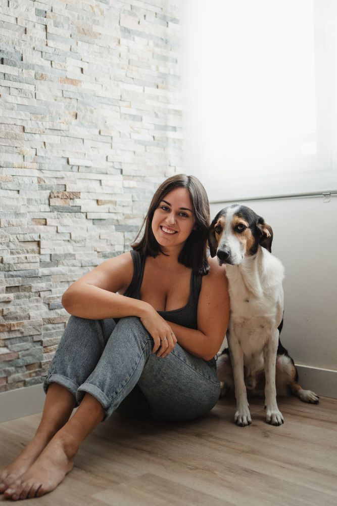 Woman with dog sitting on floor