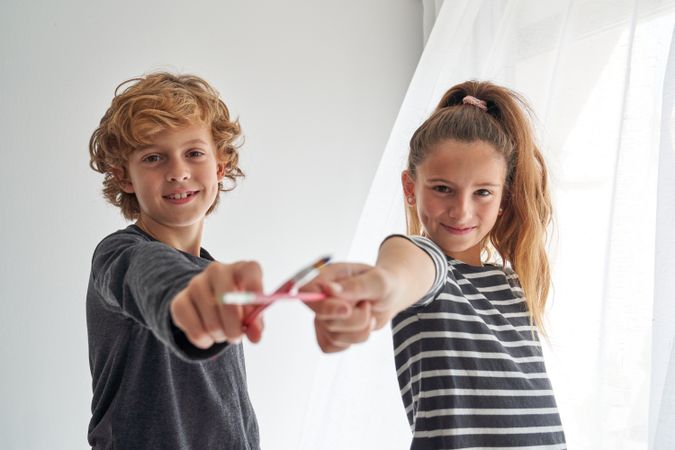 Cheerful children with paintbrushes in room