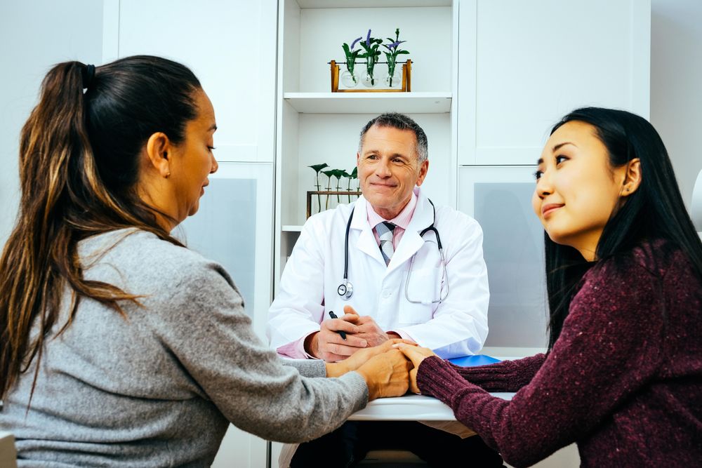 Two female patients receiving good news in doctor’s office