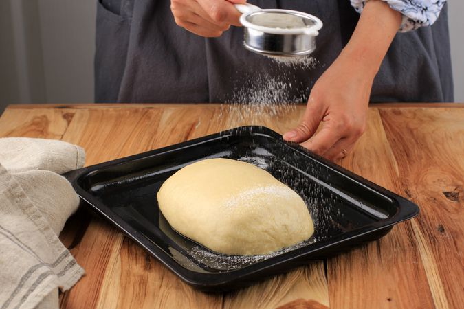 Female Bakers Hold Strainer Coating Raw Bread Dough