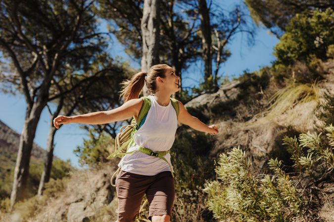 Joyful woman going for a hike with her arms out in excitement