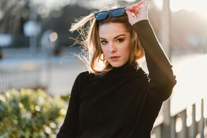 Woman taking off her sunglasses on the street